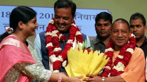 Senior Leader of India's Bharatiya Janata Party (BJP) M. Venkaiah Naidu (R) Uttar Pradesh BJP Leaders Prasad Maurya (2L) and Dinesh Sharma (2R) look on as Yogi Adityanath (C) is presented with a floral bouquet during a ceremony in Lucknow on March 18, 2017, after he was picked as the new Chief Minister of the northern Indian state of Uttar Pradesh