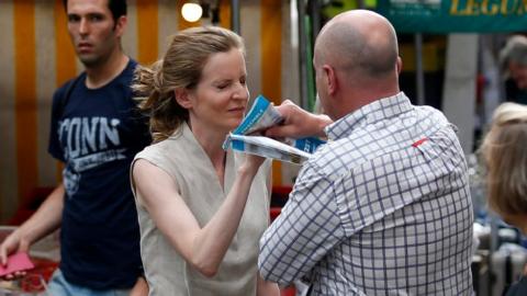 A passerby takes leaflets from the hand of Les Republicains (LR) party candidate Nathalie Kosciusko-Morizet during an altercation while campaigning in the 5th arrondissement in Paris on June 15, 2017,