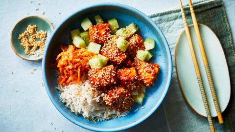 A Spicy salmon rice bowl with shredded carrots and cucumbers.