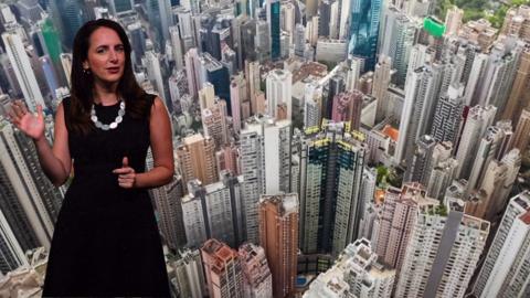 Reporter standing in front of Hong Kong skyline