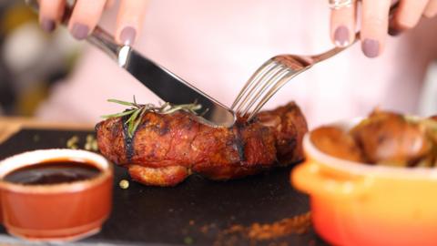 Woman cutting steak with knife and fork