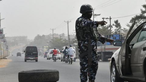 A Nigerian policeman checks a car in Anambra state. File photo