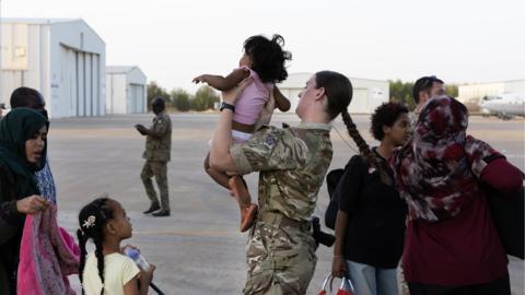 Troop holding a child during an evacuation