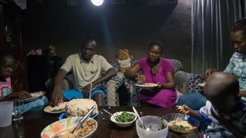 family eating dinner with electric light