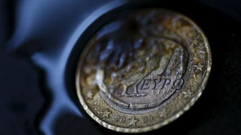 Greek euro coin in flames