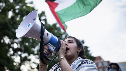 A student hold a megaphone up as he takes part in a pro-Palestinian demonstration at George Washington University in Washington DC
