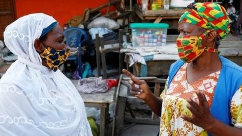 Women wearing face masks chat at the Nima market as Ghana lifts partial lockdown amid the spread of the coronavirus disease (COVID-19), in Accra, Ghana April 20, 202