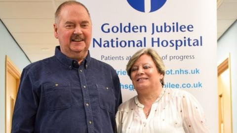 Colin standing next to his wife Susan in the hospital