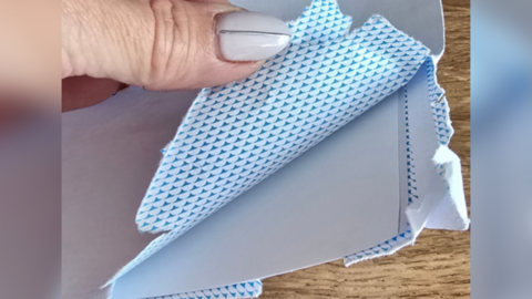 An envelope torn in a corner, in which it appears the medal has fallen out or been deliberately taken.