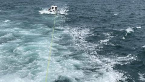 The boat being towed to shore