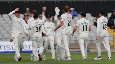 Lancashire players gather round Tom Bailey to celebrate his first of four Middlesex wickets 