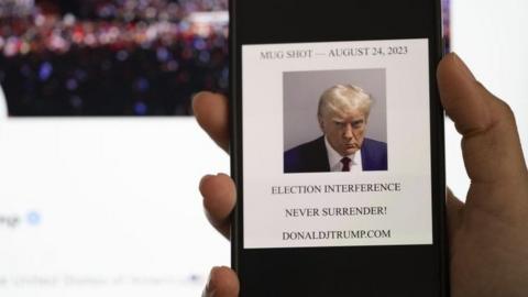 In this photo illustration, the mugshot of Former U.S. President Donald Trump is displayed on a smartphone