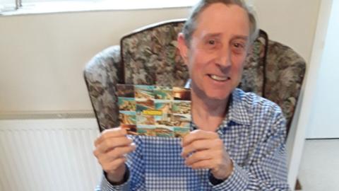 Jim Green with the postcard he sent 28 years ago