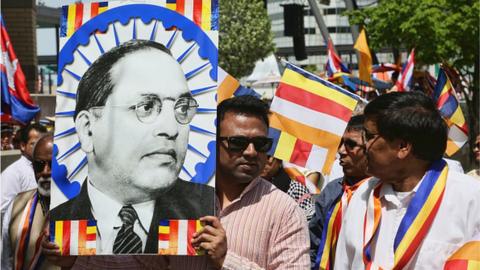 A man holds a large poster of Dr BR Ambedkar during in Canada