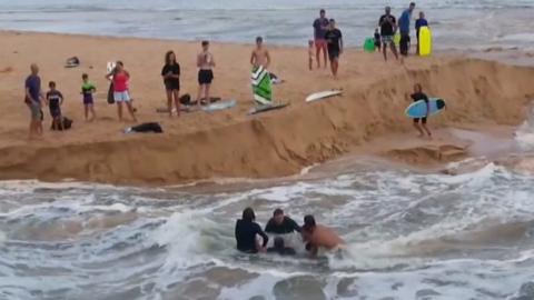 Surfers rescuing man from current