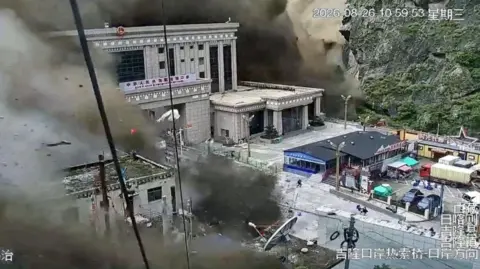 CCTV footage shows people running away as wall of mud and water destroys buildings in a valley at Nepal-China border, in Gyirong, Tibet region, China August 26, 2026, in this screengrab obtained from a social media video. SOCIAL MEDIA/via REUTERS