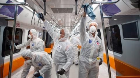 Employees of the Istanbul Municipality wearing protective gear disinfects a subway carriage 12 March 2020