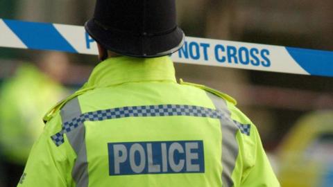 Police officer behind a cordon