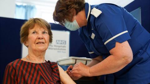 Margaret Keenan being given a vaccine by a nurse