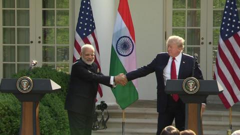 Mr Modi clamps the US president's hands firmly, offering no escape