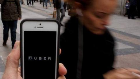 Uber logo appears on a smartphone