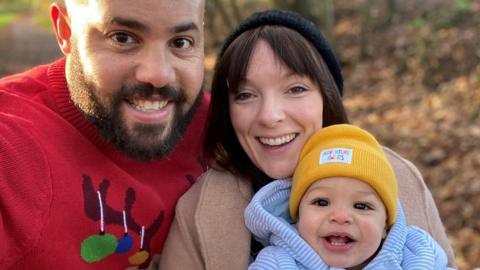 Dan Ogunshakin with his wife and child