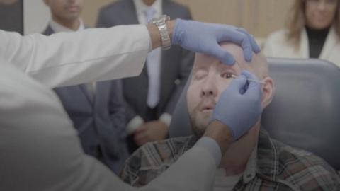 Dr Eduardo Rodriguez checks Aaron James after the first-ever eye transplant