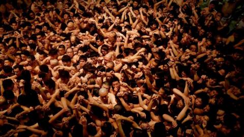 Men dressed in loincloths prepare to snatch a wooden stick called "shingi" tossed by the priest during a naked festival at Saidaiji Temple in Okayama, Okayama Prefecture Japan, 15 February 2020.