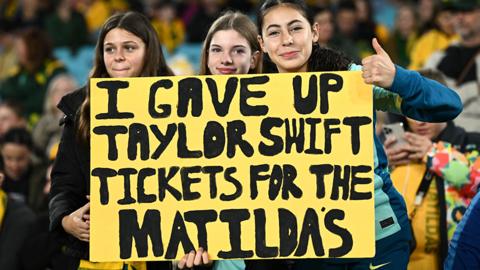 Australia supporters in Sydney at the Fifa Women's World Cup hold up a sign that reads 'I gave up Taylor Swift tickets for the Matildas'