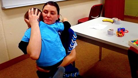 A mother in prison hugs her son