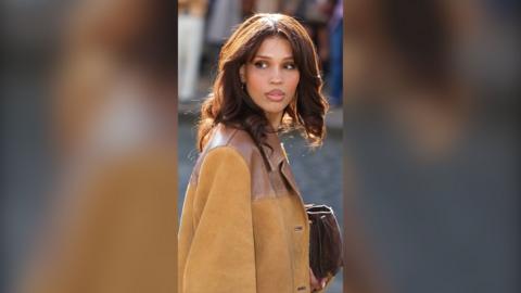 Nara Smith has brown hair ad is wearing a tan leather jacket.