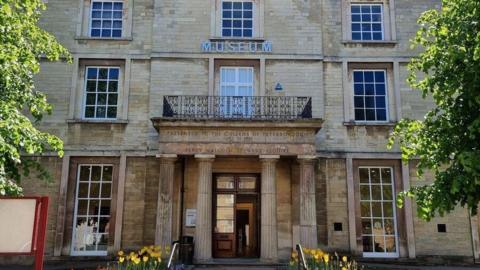 The Peterborough Museum entrance, with its Roman pillars. Three storeys are visible.