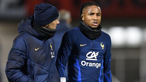 Christopher Nkunku is assisted by staff at France training session