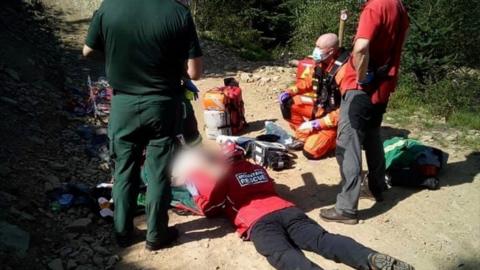 Rescuers attend to the injured cyclist