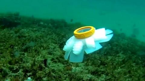 A jellyfish robot next to a coral reef
