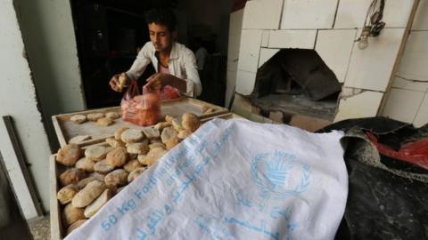 A boy collects food aid in Yemen.