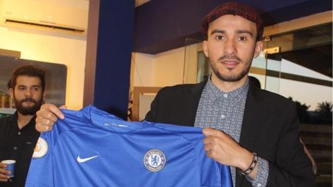 Mohammed Al-Arabi holding a Chelsea shirt