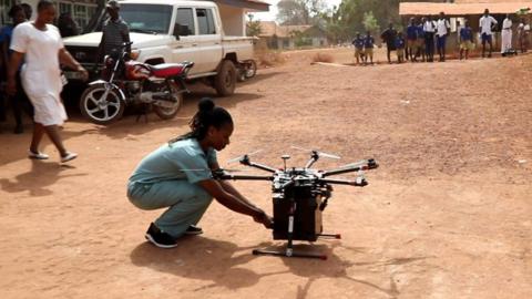 A nurse takes medical supplies from a drone