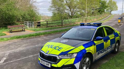 Police car at the scene where a dog walker was attacked in Astill Lodge Road, Leicester