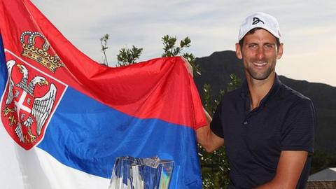 Novak Djokovic poses with a Serbian flag in 2016