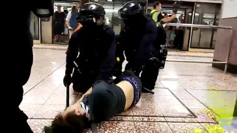 Police subdue a protester in Hong Kong