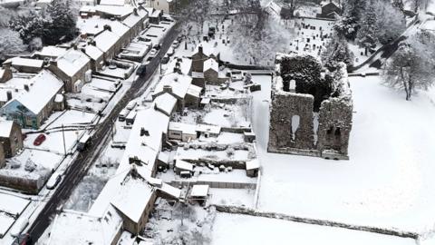 An aerial scene showing snow covering the village of Bowes, including Bowes Castle, in County Durham.