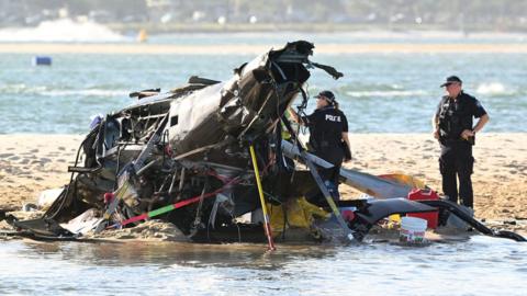 The wreckage of a helicopter on a sandbank in the Gold Coast