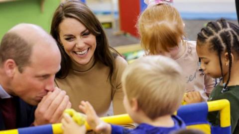 The Prince and Princess of Wales play with modelling dough as they meet children in the nursery of the Rainbow Centre