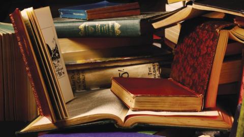 A pile of books scattered on a table