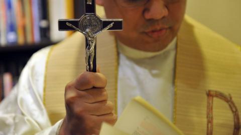 Philippine Catholic priest Father Jose Francisco Syquia, head of the Manila Archdiocese's Office of Exorcism, prays at his office in Manila on 10 March 2011