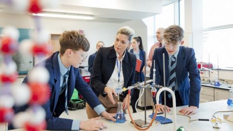 Teacher with pupils in science lab