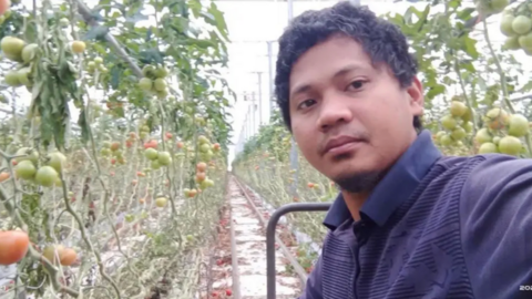 thirty year old Filipino man stood infront of a vinery. 