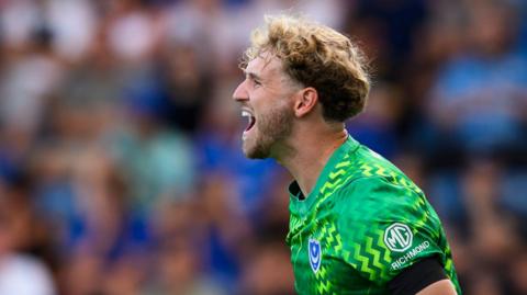Nico Schmidt, wearing his green goalkeeping kit, during Portsmouth's game against QPR