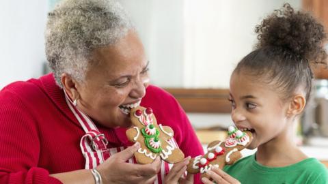 An older woman and child eat biscuits